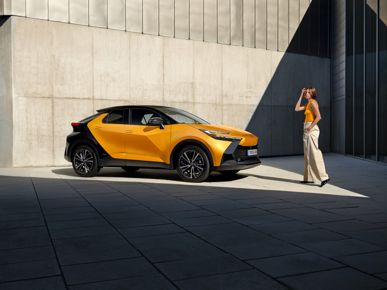 woman standing next to a Toyota C-HR