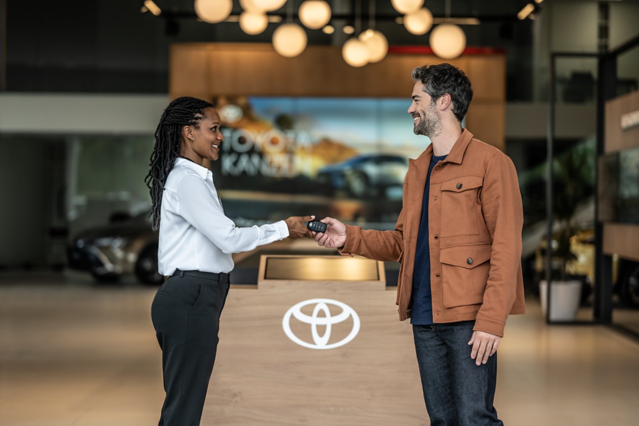 Consultant handing keys to customer at Toyota dealership
