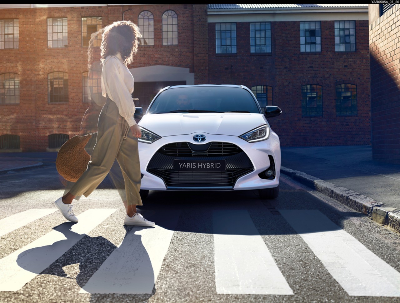 Woman walking past a Toyota Yaris