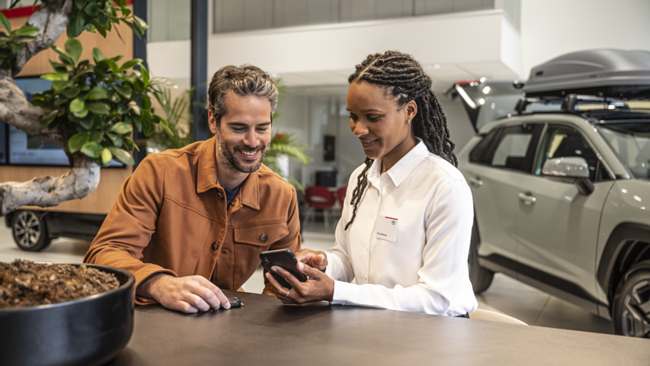 A Toyota Employee showing a consumer their phone