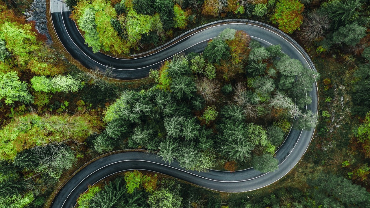 aerial view of a spiral road in a forest