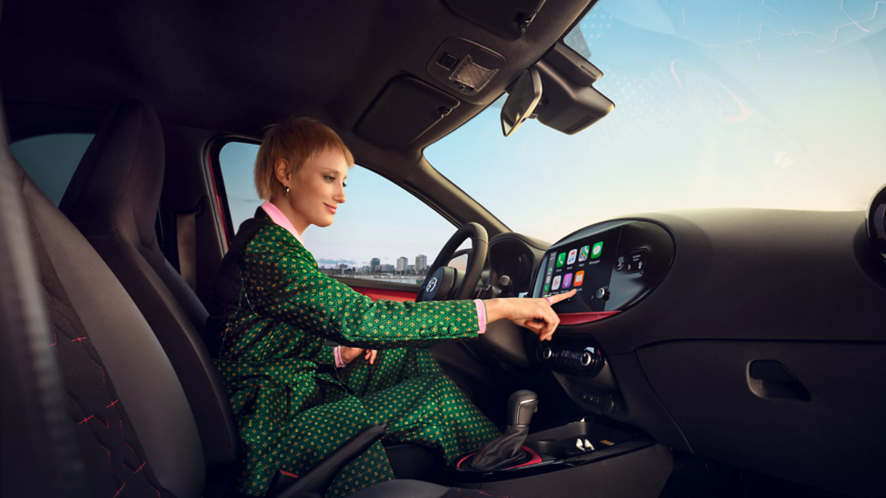 Toyota Aygo X woman touching multimedia