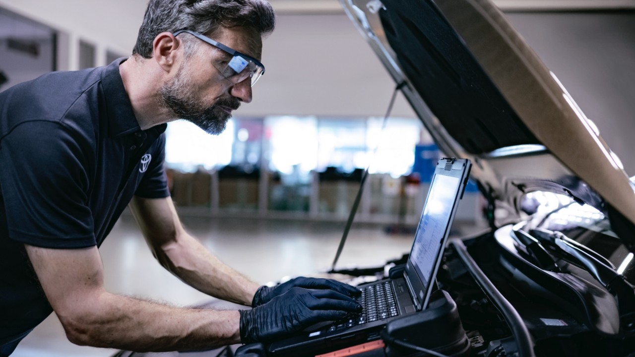 Toyota technician looking at report on laptop