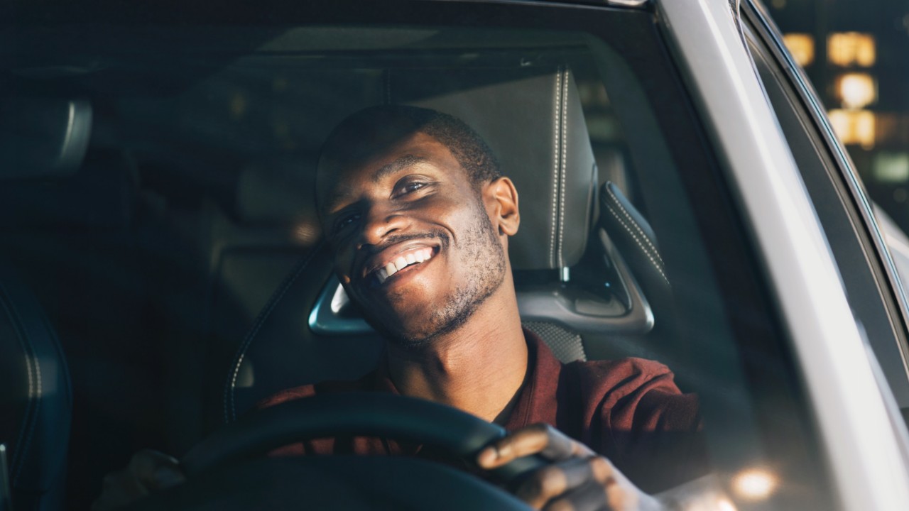 Man smiling at wheel in car