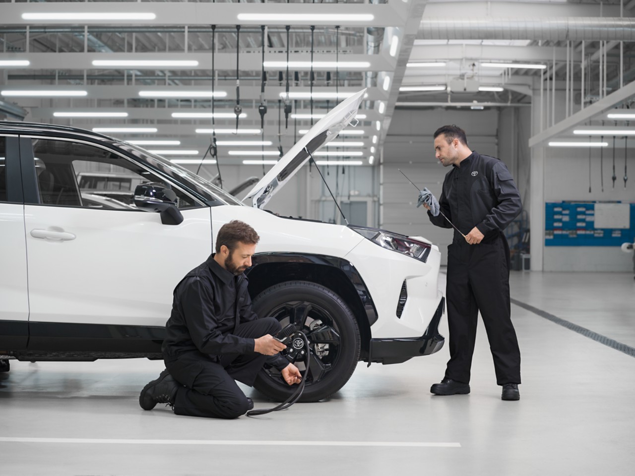 Toyota employees fixing the wheel of a car